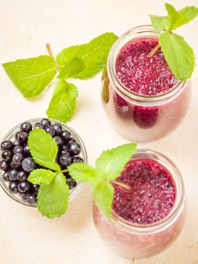 Taze yeşil nane yaprakları ve ham Olgun meyveleri yaz karışımlı vitamini kopya alanı ile kokteyl şeffaf kavanoz sarı pastel arka planda - Blueberry smoothie süslenmiş.