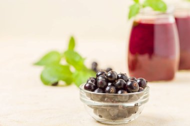 Taze yeşil nane yaprakları ve ham Olgun meyveleri yaz karışımlı vitamini sağlıklı gıda kavramı için kokteyl şeffaf kavanoz sarı pastel arka planda - frenk üzümü güler yüzlü süslenmiş.