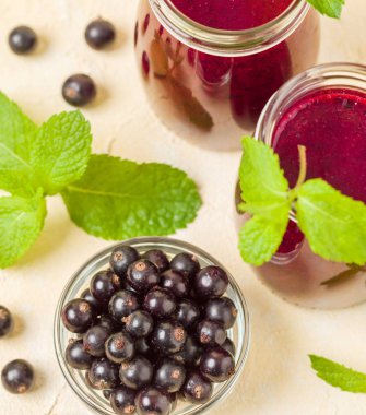 Taze yeşil nane yaprakları ve ham Olgun meyveleri yaz karışımlı vitamini sağlıklı gıda kavramı için kokteyl şeffaf kavanoz sarı pastel arka planda - frenk üzümü güler yüzlü süslenmiş.