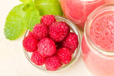 Ahududu güler yüzlü yakın taze yaz fotoğrafla kadar kokteyl ve olgun çilek sağlıklı beslenme ve yaşam tarzı konsepti için pastel sarı zemin üzerine karışık.