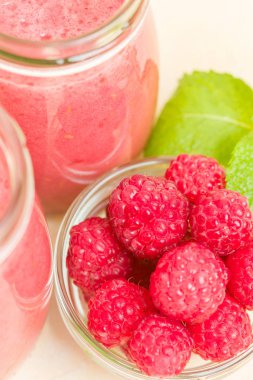 Ahududu güler yüzlü yakın taze yaz fotoğrafla kadar kokteyl ve olgun çilek sağlıklı beslenme ve yaşam tarzı konsepti için pastel sarı zemin üzerine karışık.