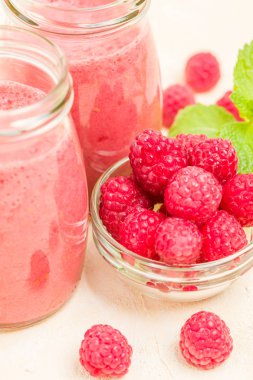 Ahududu güler yüzlü yakın taze yaz fotoğrafla kadar kokteyl ve olgun çilek sağlıklı beslenme ve yaşam tarzı konsepti için pastel sarı zemin üzerine karışık.