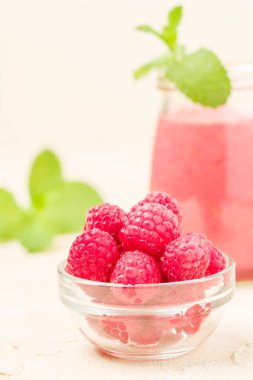 Ahududu güler yüzlü yakın taze yaz fotoğrafla kadar kokteyl ve olgun çilek sağlıklı beslenme ve yaşam tarzı konsepti için pastel sarı zemin üzerine karışık.