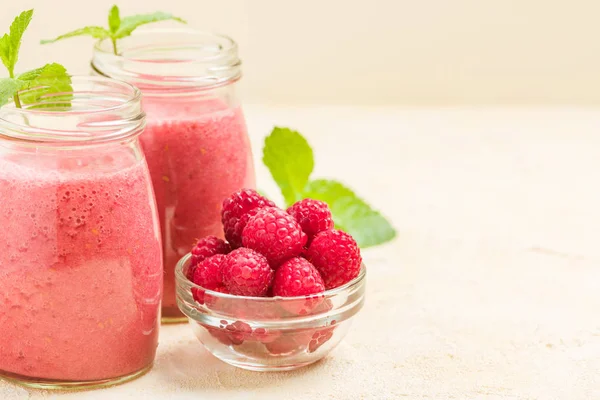 Ahududu güler yüzlü yakın taze yaz fotoğrafla kadar kokteyl ve olgun çilek sağlıklı beslenme ve yaşam tarzı konsepti için pastel sarı zemin üzerine karışık.