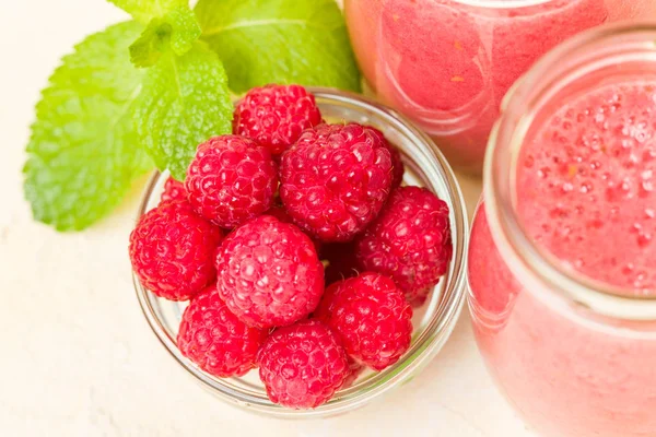 Ahududu güler yüzlü yakın taze yaz fotoğrafla kadar kokteyl ve olgun çilek sağlıklı beslenme ve yaşam tarzı konsepti için pastel sarı zemin üzerine karışık.