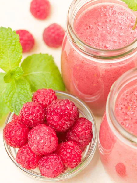 Ahududu güler yüzlü yakın taze yaz fotoğrafla kadar kokteyl ve olgun çilek sağlıklı beslenme ve yaşam tarzı konsepti için pastel sarı zemin üzerine karışık.