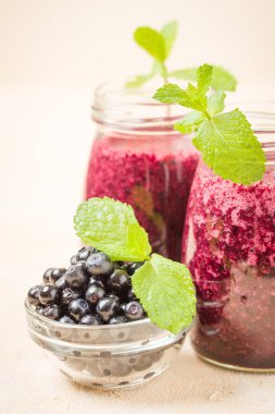 Taze yeşil nane yaprakları ve ham Olgun meyveleri yaz karışımlı vitamini kopya alanı ile kokteyl şeffaf kavanoz sarı pastel arka planda - Blueberry smoothie süslenmiş.