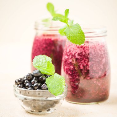 Taze yeşil nane yaprakları ve ham Olgun meyveleri yaz karışımlı vitamini kopya alanı ile kokteyl şeffaf kavanoz sarı pastel arka planda - Blueberry smoothie süslenmiş.