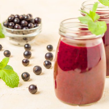 Taze yeşil nane yaprakları ve ham Olgun meyveleri yaz karışımlı vitamini sağlıklı gıda kavramı için kokteyl şeffaf kavanoz sarı pastel arka planda - frenk üzümü güler yüzlü süslenmiş.