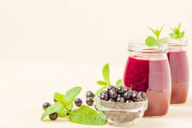 Taze yeşil nane yaprakları ve ham Olgun meyveleri yaz karışımlı vitamini sağlıklı gıda kavramı için kokteyl şeffaf kavanoz sarı pastel arka planda - frenk üzümü güler yüzlü süslenmiş.