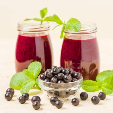 Taze yeşil nane yaprakları ve ham Olgun meyveleri yaz karışımlı vitamini sağlıklı gıda kavramı için kokteyl şeffaf kavanoz sarı pastel arka planda - frenk üzümü güler yüzlü süslenmiş.