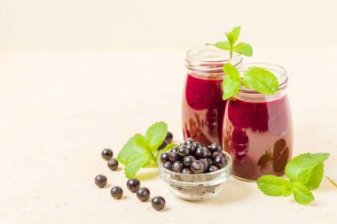 Taze yeşil nane yaprakları ve ham Olgun meyveleri yaz karışımlı vitamini sağlıklı gıda kavramı için kokteyl şeffaf kavanoz sarı pastel arka planda - frenk üzümü güler yüzlü süslenmiş.