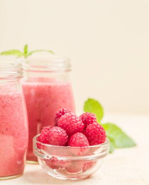 Ahududu güler yüzlü yakın taze yaz fotoğrafla kadar kokteyl ve olgun çilek sağlıklı beslenme ve yaşam tarzı konsepti için pastel sarı zemin üzerine karışık.