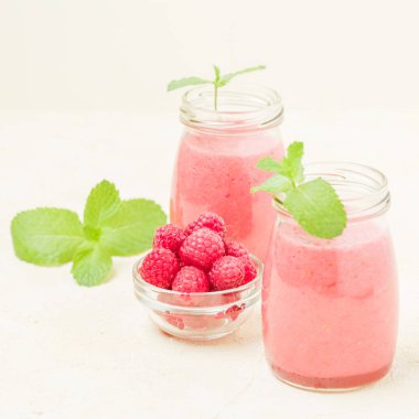 Ahududu güler yüzlü yakın taze yaz fotoğrafla kadar kokteyl ve olgun çilek sağlıklı beslenme ve yaşam tarzı konsepti için pastel sarı zemin üzerine karışık.