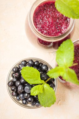 Taze yeşil nane yaprakları ve ham Olgun meyveleri yaz karışımlı vitamini kopya alanı ile kokteyl şeffaf kavanoz sarı pastel arka planda - Blueberry smoothie süslenmiş.