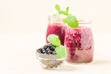 Taze yeşil nane yaprakları ve ham Olgun meyveleri yaz karışımlı vitamini kopya alanı ile kokteyl şeffaf kavanoz sarı pastel arka planda - Blueberry smoothie süslenmiş.