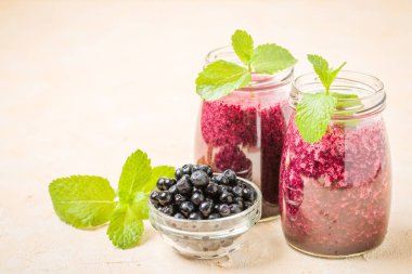 Taze yeşil nane yaprakları ve ham Olgun meyveleri yaz karışımlı vitamini kopya alanı ile kokteyl şeffaf kavanoz sarı pastel arka planda - Blueberry smoothie süslenmiş.