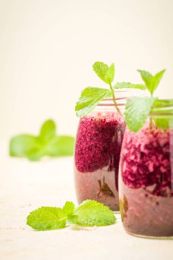 Taze yeşil nane yaprakları ve ham Olgun meyveleri yaz karışımlı vitamini kopya alanı ile kokteyl şeffaf kavanoz sarı pastel arka planda - Blueberry smoothie süslenmiş.
