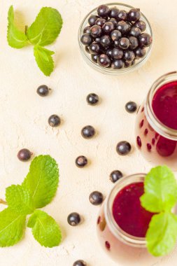 Taze yeşil nane yaprakları ve ham Olgun meyveleri yaz karışımlı vitamini sağlıklı gıda kavramı için kokteyl şeffaf kavanoz sarı pastel arka planda - frenk üzümü güler yüzlü süslenmiş.