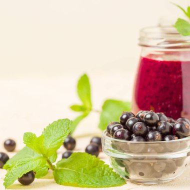 Taze yeşil nane yaprakları ve ham Olgun meyveleri yaz karışımlı vitamini sağlıklı gıda kavramı için kokteyl şeffaf kavanoz sarı pastel arka planda - frenk üzümü güler yüzlü süslenmiş.