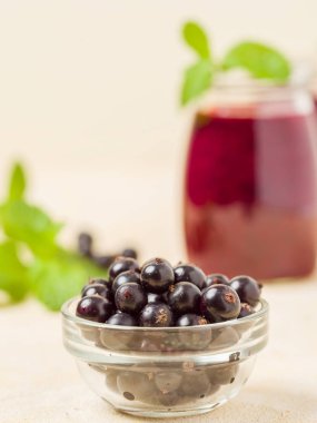 Taze yeşil nane yaprakları ve ham Olgun meyveleri yaz karışımlı vitamini sağlıklı gıda kavramı için kokteyl şeffaf kavanoz sarı pastel arka planda - frenk üzümü güler yüzlü süslenmiş.