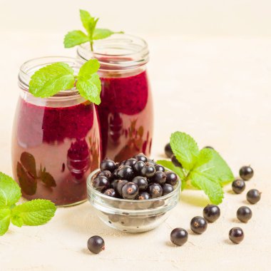 Taze yeşil nane yaprakları ve ham Olgun meyveleri yaz karışımlı vitamini sağlıklı gıda kavramı için kokteyl şeffaf kavanoz sarı pastel arka planda - frenk üzümü güler yüzlü süslenmiş.