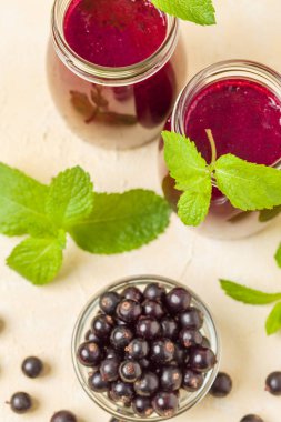 Taze yeşil nane yaprakları ve ham Olgun meyveleri yaz karışımlı vitamini sağlıklı gıda kavramı için kokteyl şeffaf kavanoz sarı pastel arka planda - frenk üzümü güler yüzlü süslenmiş.