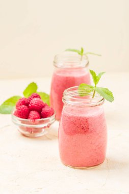 Ahududu güler yüzlü yakın taze yaz fotoğrafla kadar kokteyl ve olgun çilek sağlıklı beslenme ve yaşam tarzı konsepti için pastel sarı zemin üzerine karışık.