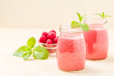 Ahududu güler yüzlü yakın taze yaz fotoğrafla kadar kokteyl ve olgun çilek sağlıklı beslenme ve yaşam tarzı konsepti için pastel sarı zemin üzerine karışık.