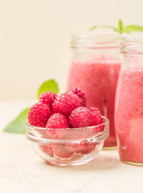 Ahududu güler yüzlü yakın taze yaz fotoğrafla kadar kokteyl ve olgun çilek sağlıklı beslenme ve yaşam tarzı konsepti için pastel sarı zemin üzerine karışık.