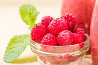 Ahududu güler yüzlü yakın taze yaz fotoğrafla kadar kokteyl ve olgun çilek sağlıklı beslenme ve yaşam tarzı konsepti için pastel sarı zemin üzerine karışık.