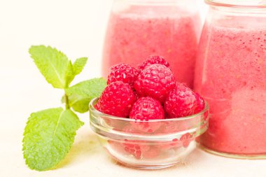 Ahududu güler yüzlü yakın taze yaz fotoğrafla kadar kokteyl ve olgun çilek sağlıklı beslenme ve yaşam tarzı konsepti için pastel sarı zemin üzerine karışık.