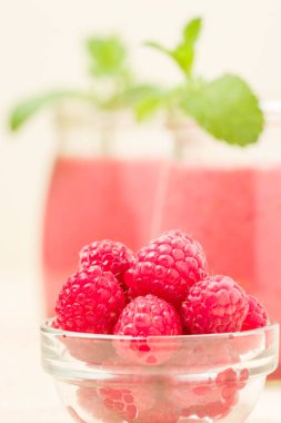 Ahududu güler yüzlü yakın taze yaz fotoğrafla kadar kokteyl ve olgun çilek sağlıklı beslenme ve yaşam tarzı konsepti için pastel sarı zemin üzerine karışık.