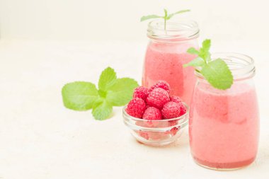 Ahududu güler yüzlü yakın taze yaz fotoğrafla kadar kokteyl ve olgun çilek sağlıklı beslenme ve yaşam tarzı konsepti için pastel sarı zemin üzerine karışık.