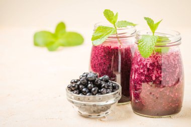 Taze yeşil nane yaprakları ve ham Olgun meyveleri yaz karışımlı vitamini kopya alanı ile kokteyl şeffaf kavanoz sarı pastel arka planda - Blueberry smoothie süslenmiş.