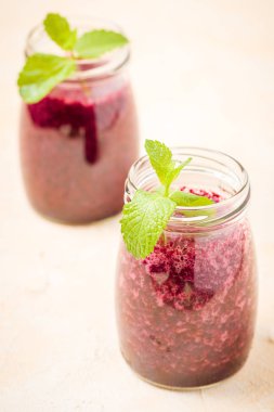 Taze yeşil nane yaprakları ve ham Olgun meyveleri yaz karışımlı vitamini kopya alanı ile kokteyl şeffaf kavanoz sarı pastel arka planda - Blueberry smoothie süslenmiş.