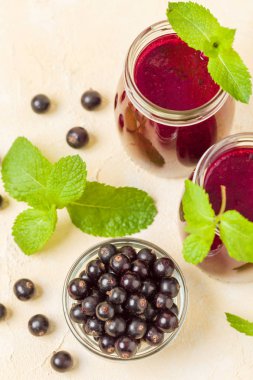 Taze yeşil nane yaprakları ve ham Olgun meyveleri yaz karışımlı vitamini sağlıklı gıda kavramı için kokteyl şeffaf kavanoz sarı pastel arka planda - frenk üzümü güler yüzlü süslenmiş.