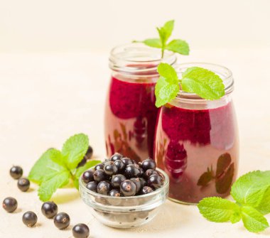 Taze yeşil nane yaprakları ve ham Olgun meyveleri yaz karışımlı vitamini sağlıklı gıda kavramı için kokteyl şeffaf kavanoz sarı pastel arka planda - frenk üzümü güler yüzlü süslenmiş.