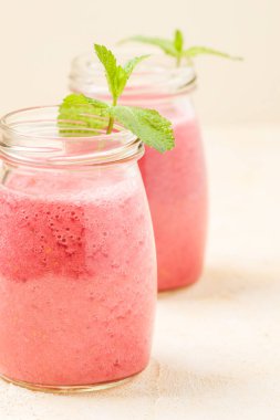 Ahududu güler yüzlü yakın taze yaz fotoğrafla kadar kokteyl ve olgun çilek sağlıklı beslenme ve yaşam tarzı konsepti için pastel sarı zemin üzerine karışık.