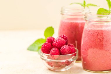 Ahududu güler yüzlü yakın taze yaz fotoğrafla kadar kokteyl ve olgun çilek sağlıklı beslenme ve yaşam tarzı konsepti için pastel sarı zemin üzerine karışık.