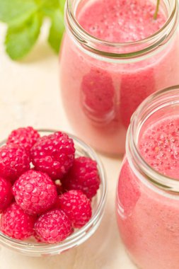 Ahududu güler yüzlü yakın taze yaz fotoğrafla kadar kokteyl ve olgun çilek sağlıklı beslenme ve yaşam tarzı konsepti için pastel sarı zemin üzerine karışık.