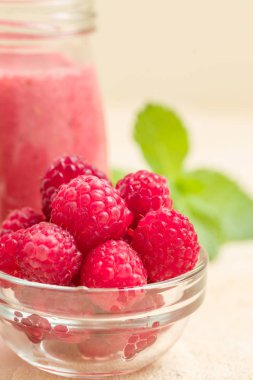 Ahududu güler yüzlü yakın taze yaz fotoğrafla kadar kokteyl ve olgun çilek sağlıklı beslenme ve yaşam tarzı konsepti için pastel sarı zemin üzerine karışık.