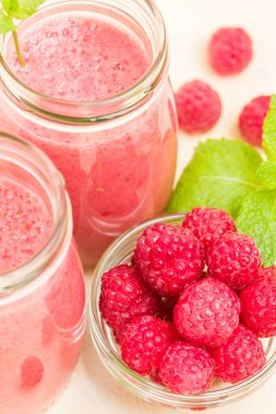 Ahududu güler yüzlü yakın taze yaz fotoğrafla kadar kokteyl ve olgun çilek sağlıklı beslenme ve yaşam tarzı konsepti için pastel sarı zemin üzerine karışık.