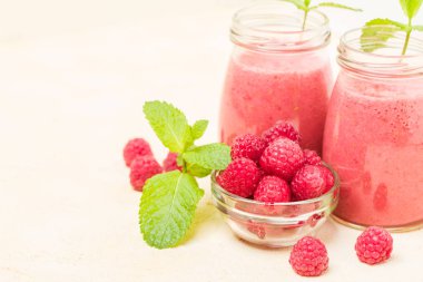 Ahududu güler yüzlü yakın taze yaz fotoğrafla kadar kokteyl ve olgun çilek sağlıklı beslenme ve yaşam tarzı konsepti için pastel sarı zemin üzerine karışık.