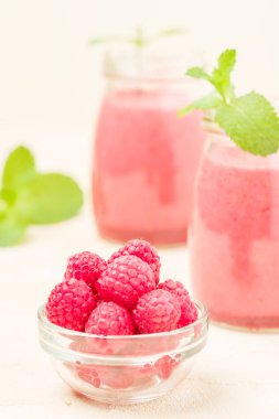 Ahududu güler yüzlü yakın taze yaz fotoğrafla kadar kokteyl ve olgun çilek sağlıklı beslenme ve yaşam tarzı konsepti için pastel sarı zemin üzerine karışık.