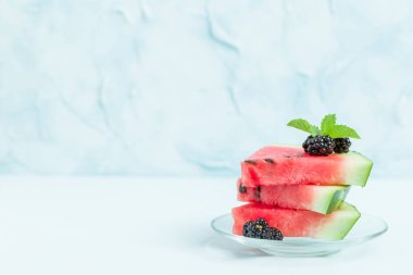 Pasta böğürtlen ve nane yaprağı ile kopya alanı - pastel mavi zemin üzerine dilimlenmiş karpuz yakın çekim yaz taze çiğ olgunlaşmış meyve lezzetli vejetaryen tatlı makro fotoğrafçılık.