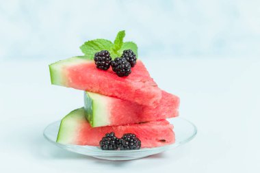 Pasta böğürtlen ve nane yaprağı ile kopya alanı - pastel mavi zemin üzerine dilimlenmiş karpuz yakın çekim yaz taze çiğ olgunlaşmış meyve lezzetli vejetaryen tatlı makro fotoğrafçılık.