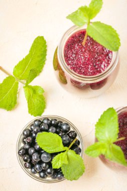 Taze yeşil nane yaprakları ve ham Olgun meyveleri yaz karışımlı vitamini kopya alanı ile kokteyl şeffaf kavanoz sarı pastel arka planda - Blueberry smoothie süslenmiş.