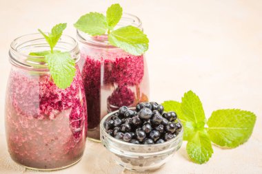 Taze yeşil nane yaprakları ve ham Olgun meyveleri yaz karışımlı vitamini kopya alanı ile kokteyl şeffaf kavanoz sarı pastel arka planda - Blueberry smoothie süslenmiş.