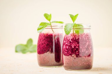 Taze yeşil nane yaprakları ve ham Olgun meyveleri yaz karışımlı vitamini kopya alanı ile kokteyl şeffaf kavanoz sarı pastel arka planda - Blueberry smoothie süslenmiş.